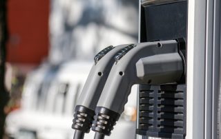 A pair of grey electric car chargers rest comfortably on the charging stations