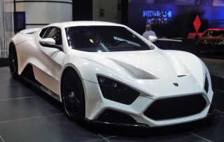 A gleaming, white Zenvo ST1 sits in a grey garage.