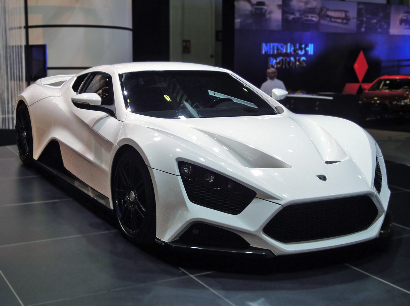 A gleaming, white Zenvo ST1 sits in a grey garage.