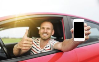 A man in a car with smartphone