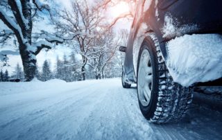 Car tire drives down winter road.