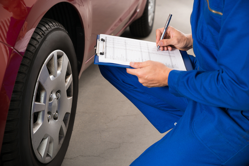 An inspector checks off a vehicle.