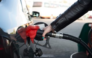 A lady fills her car with gas.