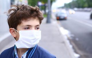 Boy wears medical mask outside