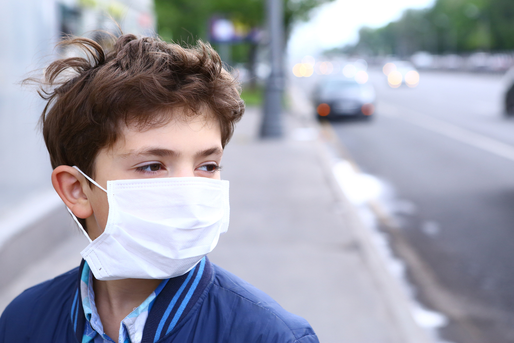 Boy wears medical mask outside