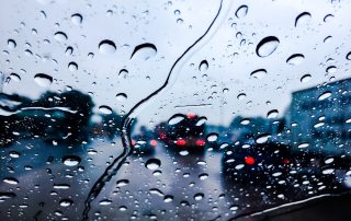 Raindrops hitting windshield in car