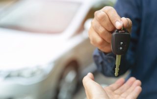 car dealer handing over keys to a new car