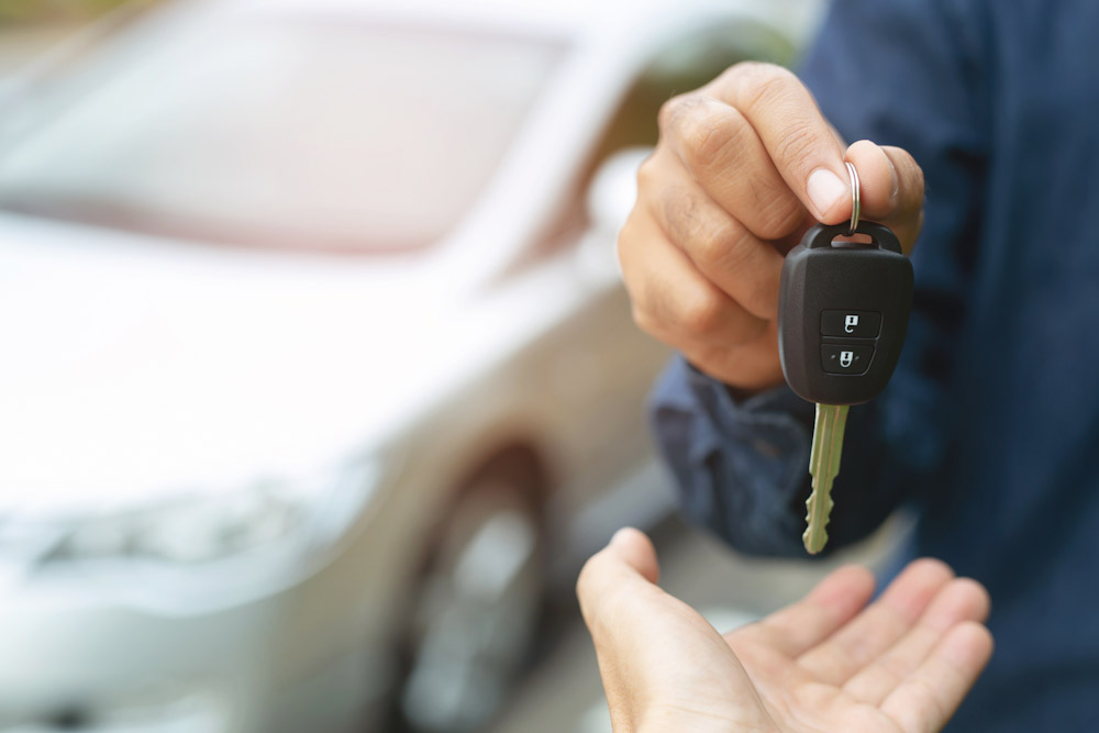 car dealer handing over keys to a new car