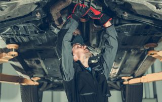 Car mechanic underneath a car.