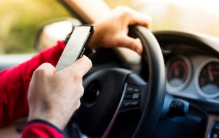 Image of man texting while behind the wheel of his car