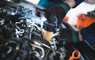 Filter being installed by mechanic under the hood of a car