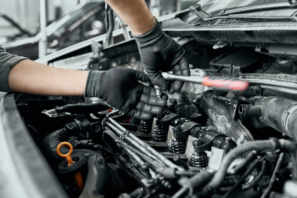 Mechanic repairing car engine.