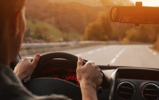 Man driving car down mountain pass.