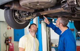 mechanic and man examining car