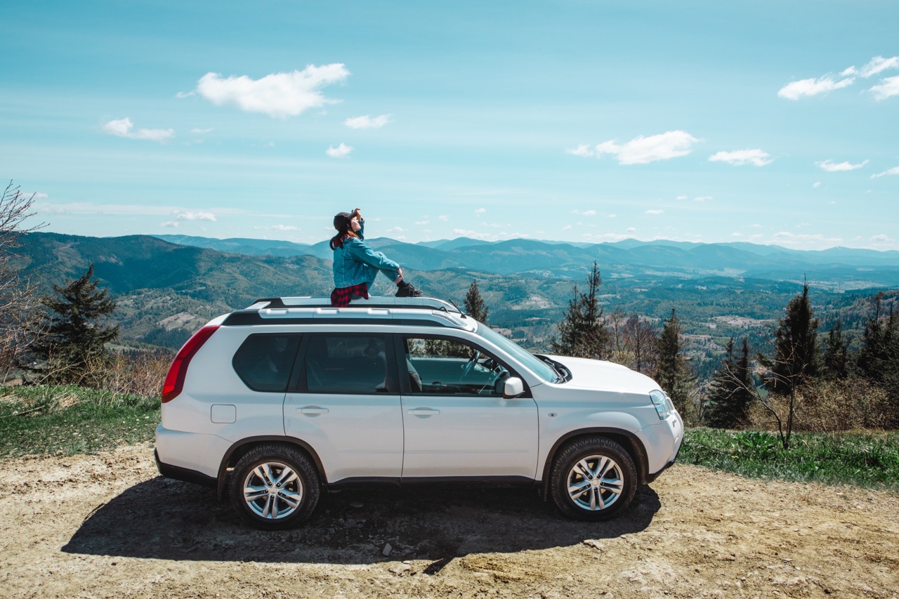 man sitting atop car in summer