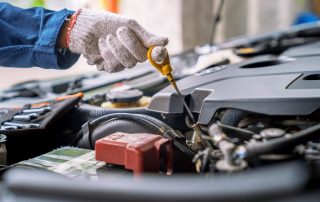 mechanic checks engine oil