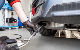 mechanic conducts emissions test on car