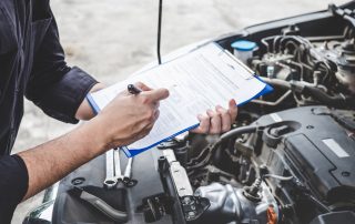 man checks car to-do list