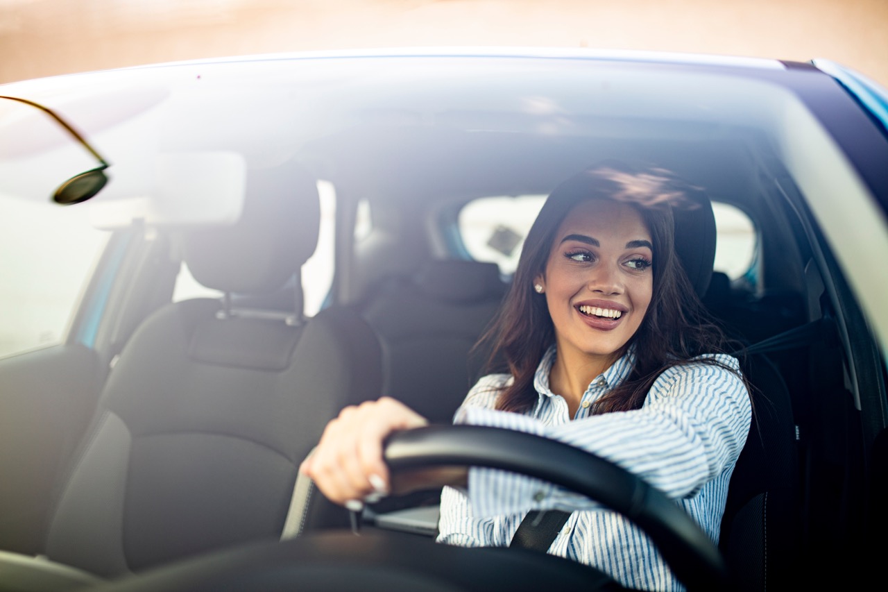 woman driving car happily