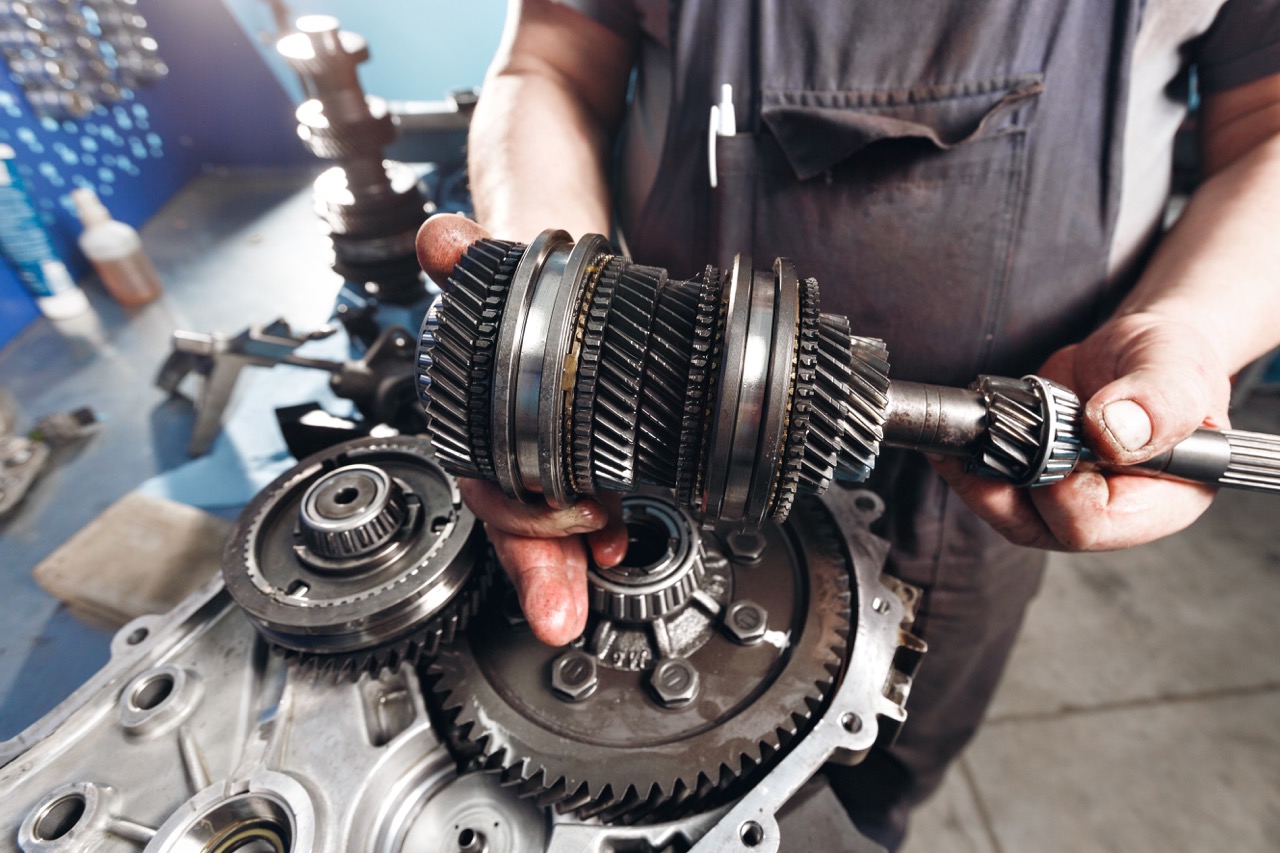 mechanic repairing car transmission