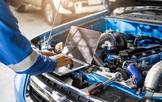 mechanic conducts engine diagnostics test on car