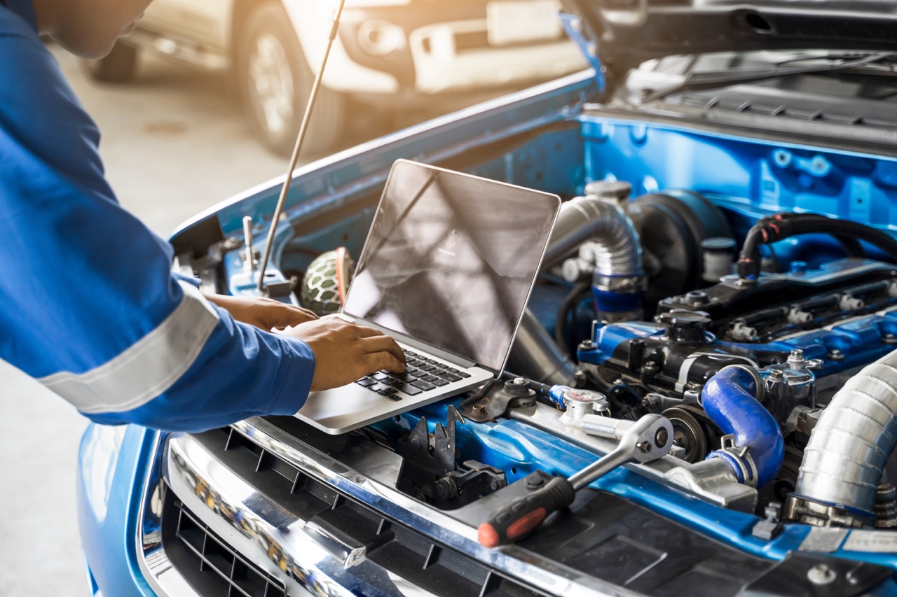 mechanic conducts engine diagnostics test on car