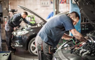 mechanics working on cars in auto shop