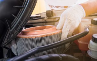 mechanic changes filter in car engine