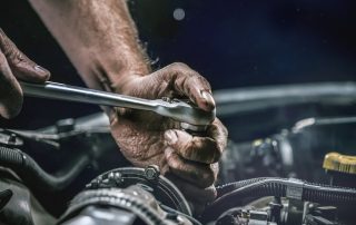 mechanic fixes car transmission