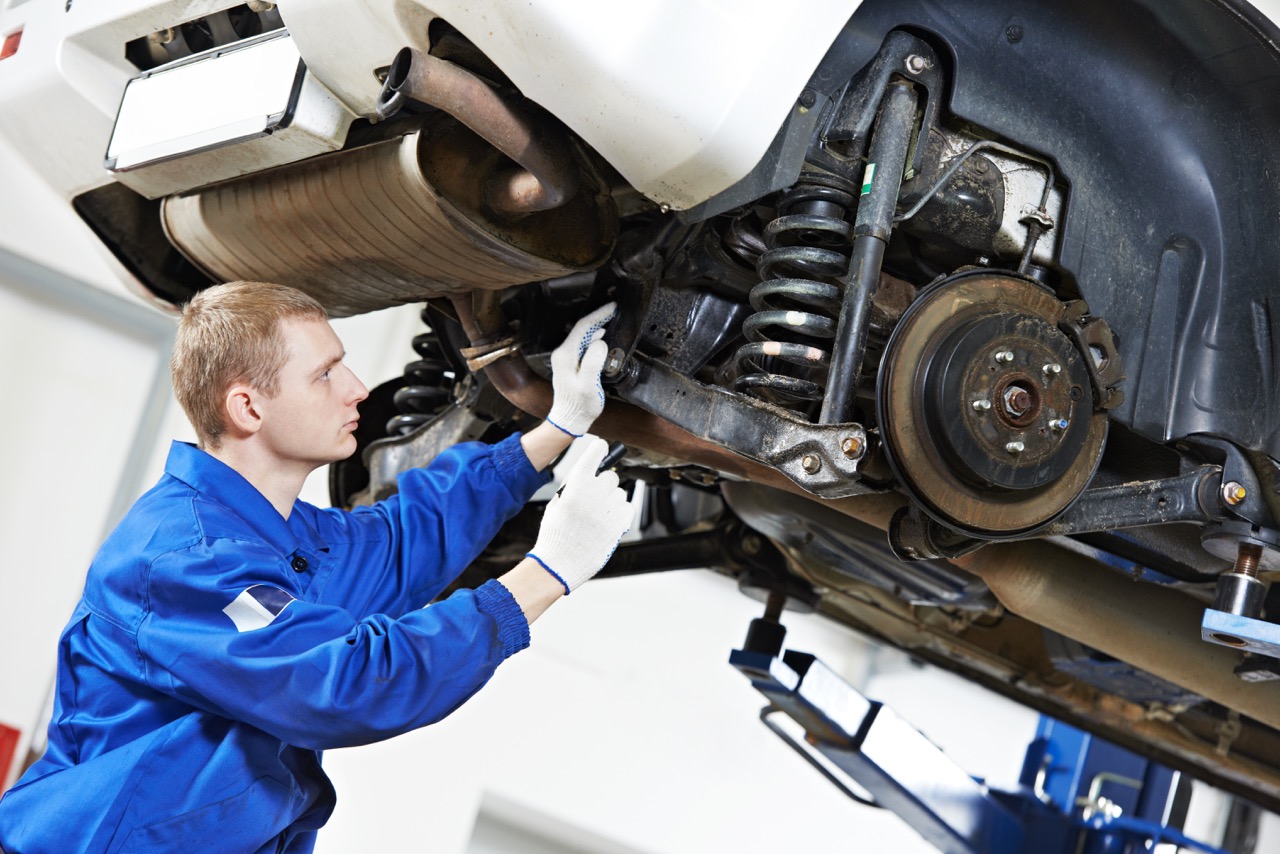 auto mechanic checks car suspension