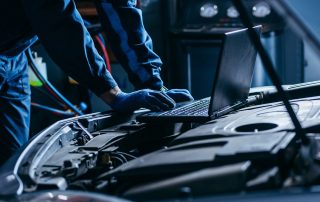 mechanic performs tune up on car