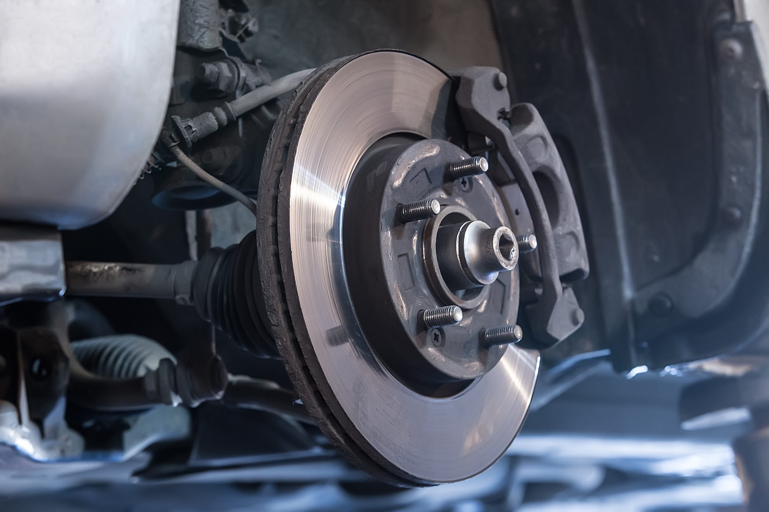 Brake pad, caliper, and rotor on car