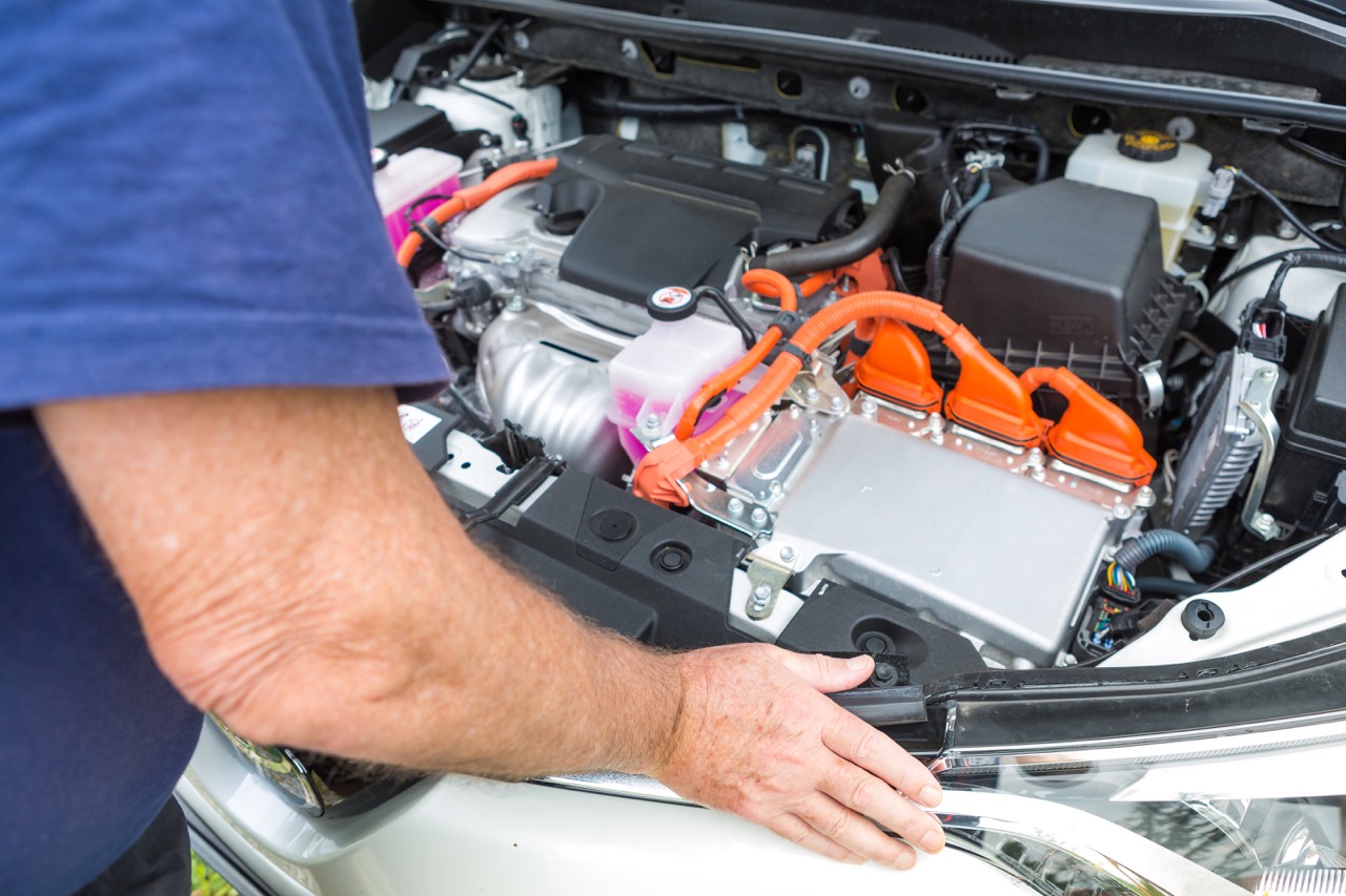 mechanic under the hood of an electric vehicle