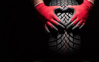 mechanic holds a new car tire