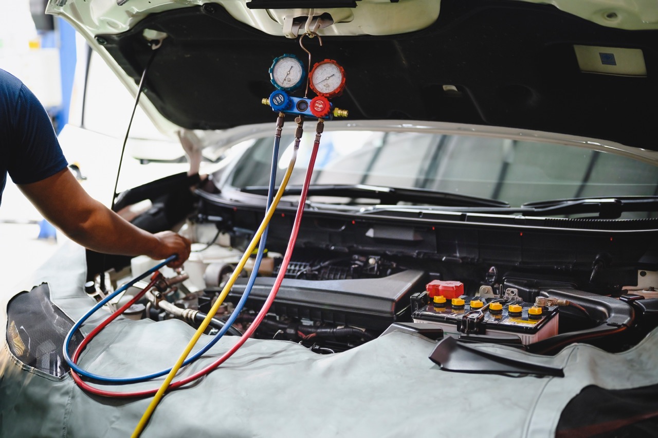 mechanic recharging a car's ac system