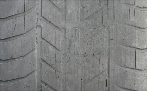 Close up of an old tire with worn, cracking treads